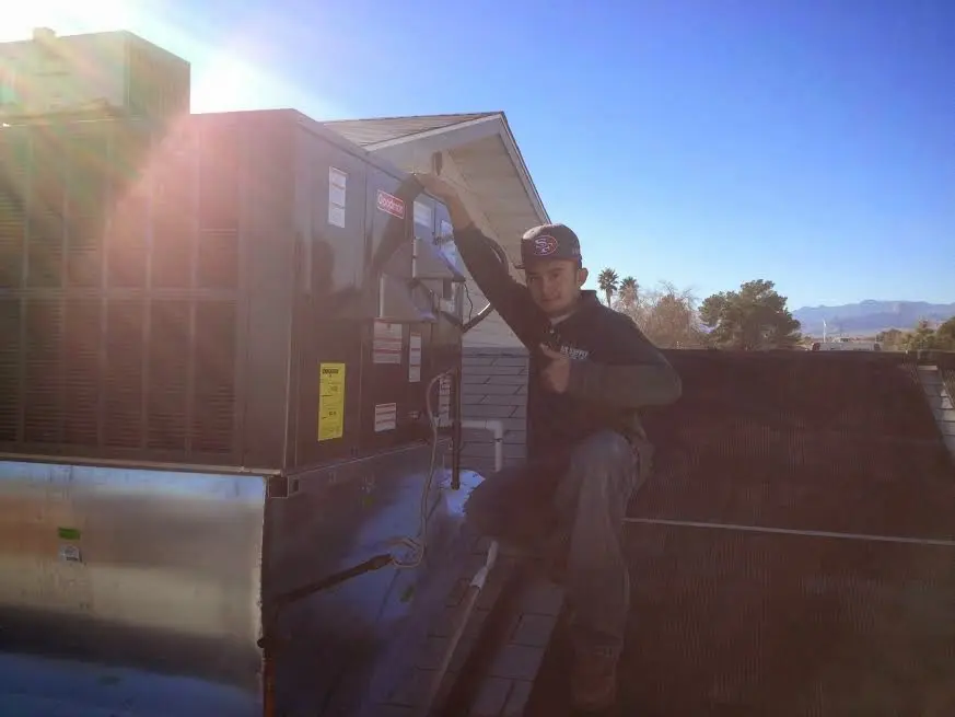 HVAC technician performing Air Duct Cleaning on a rooftop unit in Berkeley